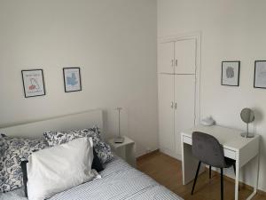 a bedroom with a bed with a desk and a chair at Appartement moderne metro 9 in Boulogne-Billancourt