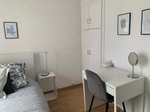 a bedroom with a desk and a bed with a chair at Appartement moderne metro 9 in Boulogne-Billancourt