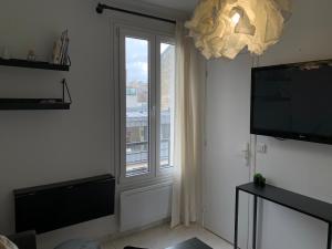 a living room with a window and a television at Appartement moderne metro 9 in Boulogne-Billancourt