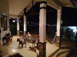 a woman sitting at a table on a patio at night at Luxurious private room with bathroom in mountaine in Sorá