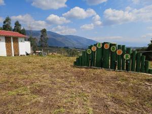 a sign in a field with mountains in the background at Zona de Camping El mirador in Villa de Leyva