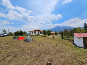 two tents in a field with mountains in the background at Zona de Camping El mirador in Villa de Leyva