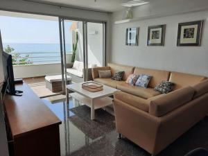 un salon avec un canapé et une table dans l'établissement Apartamento con acceso directo al mar en Altea y parking, à Altea