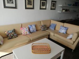 - un salon avec un canapé et des oreillers dans l'établissement Apartamento con acceso directo al mar en Altea y parking, à Altea