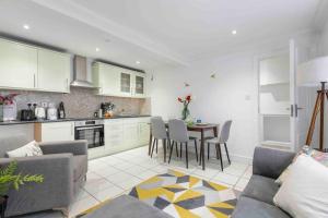 a kitchen and living room with a table and chairs at Hyde Park/Paddington Flat in London