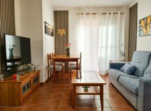 una sala de estar con un sofá y una mesa en Azohia Wellness, en La Azohía