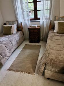 a living room with two beds and a window at Quinta Souto da Ordem - House in Castelo Novo
