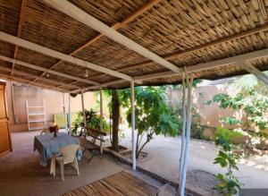 a porch with a table and chairs and a tree at Villa keur Fatou in Sali Nianiaral