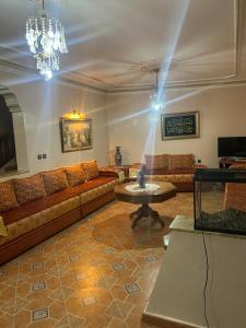 a living room with a couch and a table at Villa luxueuse et familiale in Tétouan