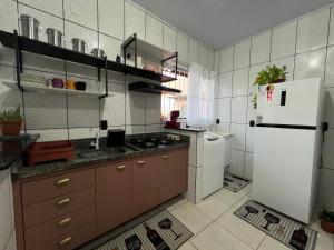 uma cozinha com um frigorífico branco e um lavatório em Loft 05 Excelente Localização em Cuiabá