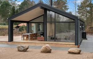 Nyrup的住宿－Gorgeous Home In Nykbing Sj With Kitchen，一座带大窗户和两块岩石的小房子