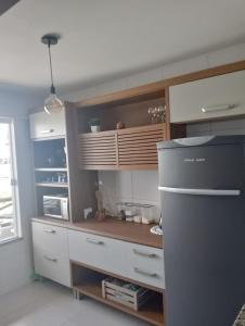 a kitchen with white cabinets and a counter at Apartamento no Condomínio Vila das Águas in Estância