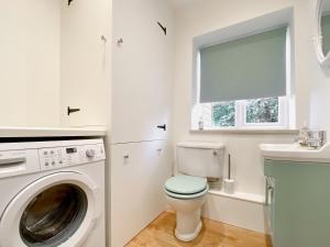 baño blanco con lavadora y lavamanos en Middle Farm Cottage en Avebury