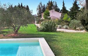 einen Hinterhof mit einem Pool im Gras in der Unterkunft Le Cabanon in Maussane-les-Alpilles