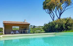 ein Swimmingpool mit zwei Stühlen und einem Haus in der Unterkunft Le Cabanon in Maussane-les-Alpilles