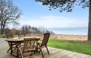 einen Tisch und Stühle auf einer Terrasse mit Blick auf den Strand in der Unterkunft Cozy Home In Holbk With House Sea View in Holbæk