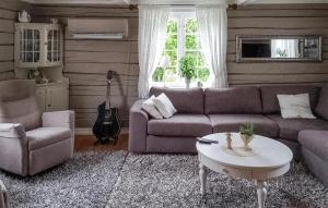 Sala de estar con sofá, mesa y guitarra en Beautiful Home In Kolvereid With Kitchen en Kolvereid
