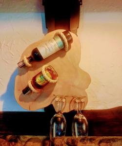 Duas garrafas de vinho e dois copos de vinho numa mesa em Cabaña en el Arbol Picasso em Bogotá