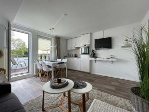 a living room with a couch and a table and a kitchen at 50113 Ferienwohnung "Chanel" in Carolinensiel