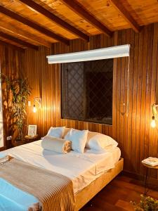 a bedroom with a large bed with a light above it at Renacer Santa Elena in Medellín