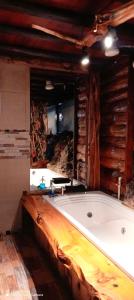 bañera grande en una habitación con pared de madera en Cabaña en el Arbol Picasso en Bogotá