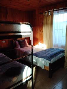 a bedroom with two bunk beds and a window at Cabaña de descanso in Las Cruces