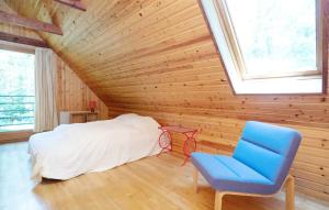 Stunning Home In Frederiksvrk With Wifi في Frederiksværk: غرفة نوم بسرير وكرسي ازرق