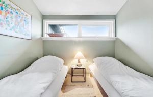 2 Betten in einem kleinen Zimmer mit Fenster in der Unterkunft 3 Bedroom Cozy Home In Vejby in Vejby