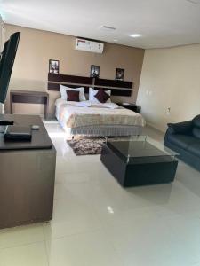 ein großes Schlafzimmer mit einem Bett und einem Sofa in der Unterkunft Serra's Palace Hotel in Parauapebas