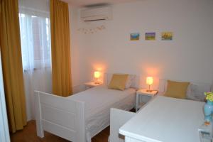 a bedroom with a bed and two lamps on tables at Holiday house with a parking space Svirce, Hvar - 22571 in Jelsa