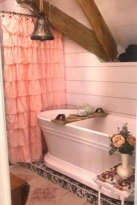 a bathroom with a tub and a pink shower curtain at Its Day One I Do Bridal Dressing Suite in Nassau