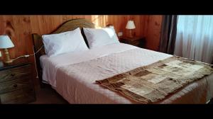 a bedroom with a large bed with white sheets and pillows at Cabaña de descanso in Las Cruces