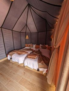 1 dormitorio con 2 camas en una tienda de campaña en Merzouga Dunes Luxury Camps, en Merzouga