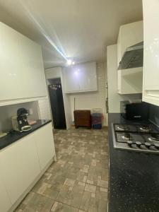 a kitchen with white cabinets and a tile floor at 9 Russell court, king close in London