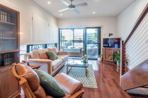 a living room with a couch and a tv at Beautiful Modern Home in Heart of New Farm in Brisbane