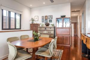 a dining room with a wooden table and chairs at Beautiful Modern Home in Heart of New Farm in Brisbane