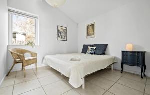 een slaapkamer met een bed, een stoel en een raam bij Awesome Home In Vejby With Kitchen in Vejby