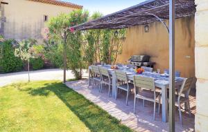 a table and chairs under an umbrella in a backyard at Le Mas D'edith in Maussane-les-Alpilles