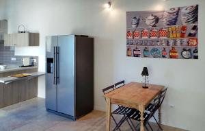 a kitchen with a table and a stainless steel refrigerator at Le Mas D'edith in Maussane-les-Alpilles +30 photos