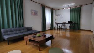 - un salon avec un canapé et une table dans l'établissement SecondHouse Otaru Garden, à Otaru