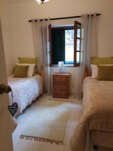 a bedroom with two beds and a window at Quinta Souto da Ordem - House in Castelo Novo