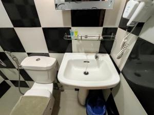 a bathroom with a white toilet and a sink at Tambun Warm Hotel in Ipoh