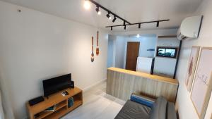 pequeña sala de estar con TV y cocina en Vista Mar em Villa del Sol Residences - unidade autônoma, en Río de Janeiro