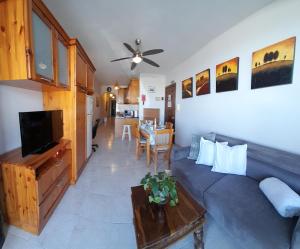 a living room with a blue couch and a table at Seafront Maisonette Ocean Views & Terrace in Mellieħa