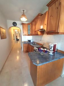 a kitchen with wooden cabinets and a counter top at Seafront Maisonette Ocean Views & Terrace in Mellieħa