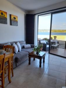 a living room with a couch and a table at Seafront Maisonette Ocean Views & Terrace in Mellieħa