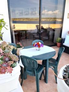 a table and chairs on a patio with potted plants at Seafront Maisonette Ocean Views & Terrace in Mellieħa