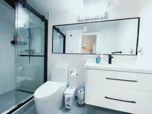 a bathroom with a toilet and a glass shower at Private, Spacious Apt Suite w/ Deck Free Parking in Mississauga