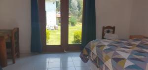 ein Schlafzimmer mit einem Bett und einer Tür zum Hof in der Unterkunft Hotel Rancho Escondido in Valle de Bravo