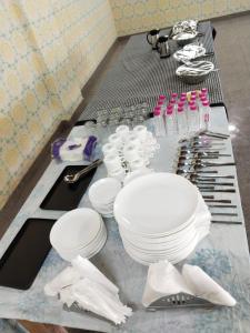 a table with white plates and utensils on it at HOTEL METRO REGENCY INN in Jaipur +26 photos